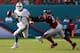 MIAMI GARDENS, FL - SEPTEMBER 22: Quarterback Ryan Tannehill #17 of the Miami Dolphins scrambles away from Defensive lineman Johnathan Massaquoi #96 of the Atlanta Falcons at Sun Life Stadium on September 22, 2013 in Miami Gardens, Florida. The Dolphins
