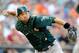 BALTIMORE, MD - AUGUST 24: Kurt Suzuki #22 of the Oakland Athletics fields a bunt and throws to first base in the eighth inning against the Baltimore Orioles at Oriole Park at Camden Yards on August 24, 2013 in Baltimore, Maryland. (Photo by Greg Fiume/
