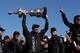 SAN FRANCISCO, CA - SEPTEMBER 25: Oracle Team USA tactician Sir Ben Ainslie (C) holds the America's Cup trophy as he celebrates onstage after they beat Emirates Team New Zealand to defend the America's Cup during the final race on September 25, 2013 in