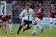 NORTHAMPTON, ENGLAND - AUGUST 06: Patrick Bamford of MK Dons turns away with the ball from Danny Emerton of Northampton Town during the Capital One Cup First Round match between Northampton Town and MK Dons at Sixfields Stadium on August 6, 2013 in North