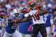 ORCHARD PARK, NY - OCTOBER 13: A.J. Green #18 of the Cincinnati Bengals picks up 55 yards on a catch during NFL game action as Da'Norris Searcy #25 of the Buffalo Bills tackles him at Ralph Wilson Stadium on October 13, 2013 in Orchard Park, New York. (Ph