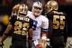 NEW ORLEANS - DECEMBER 19: Quarterback Tony Romo #9 of the Dallas Cowboys taps Tracy Porter #22 of the New Orleans Saints during the game against the New Orleans Saints at Louisiana Superdome on December 19, 2009 in New Orleans, Louisiana. (Photo by Chr
