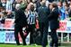 NEWCASTLE UPON TYNE, ENGLAND - OCTOBER 19: Manager Alan Pardew of Newcastle United touches hands with Mapou Yanga-Mbiwa of Newcastle United as he makes his way of the pitch after being shown a red card during the Barclays Premier League match between Newc