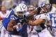 INDIANAPOLIS, IN - OCTOBER 20: Trent Richardson #34 of the Indianapolis Colts looks to escape a tackle by Derek Wolfe #95 of the Denver Broncos at Lucas Oil Stadium on October 20, 2013 in Indianapolis, Indiana. The Colts beat the Broncos 39-33. (Photo b