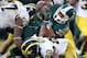 EAST LANSING, MI - NOVEMBER 02: Frank Clark #57 and Jarrod Wilson #22 of the Michigan Wolverines bring down Jeremy Langford #33 of the Michigan State Spartans in the fourth quarter at Spartan Stadium on November 2, 2013 in East Lansing, Michigan. Michig