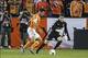 Oct 31, 2013; Houston, TX, USA; Houston Dynamo forward Will Bruin (12) scores a goal past Montreal Impact goalkeeper Troy Perkins (1) during the second half at BBVA Compass Stadium. The Dynamo defeated the Impact 3-0. Mandatory Credit: Troy Taormina-USA T