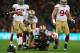 Justin Smith (No. 94) watches Dan Skuta (No. 51) give Glenn Dorsey (No. 90) a pat on the back for his tackle in run defense.