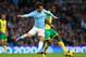 MANCHESTER, ENGLAND - NOVEMBER 02: David Silva of Manchester City competes with Sebastien Bassong of Norwich during the Barclays Premier League match between Manchester City and Norwich City at Etihad Stadium on November 2, 2013 in Manchester, England.