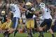 SOUTH BEND, IN - OCTOBER 20: Kapron Lewis-Moore #89 of the Notre Dame Fighting Irish rushes between Ryker Matthews #72 and Braden Hansen #76 of the BYU Cougars at Notre Dame Stadium on October 20, 2012 in South Bend, Indiana. Notre Dame defeated BYU 17-1