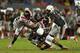 MIAMI GARDENS, FL - NOVEMBER 09: Dallas Crawford #25 of the Miami Hurricanes is tackled by Kendall Fuller #11 of the Virginia Tech Hokies during a game at Sun Life Stadium on November 9, 2013 in Miami Gardens, Florida. (Photo by Mike Ehrmann/Getty Imag