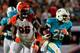 MIAMI GARDENS, FL - OCTOBER 31: (R) Lamar Miller #26 of the Miami Dolphins runs with the ball under pressure from Carlos Dunlap #96 of the Cincinnati Bengals at Sun Life Stadium on October 31, 2013 in Miami Gardens, Florida. (Photo by Chris Trotman/Getty