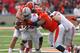 CHAMPAIGN, IL - NOVEMBER 16: Carlos Hyde #34 of the Ohio State Buckeyes drags tacklers Houston Bates #55 and Teko Powell #93 of the Illinois Fighting Illini at Memorial Stadium on November 16, 2013 in Champaign, Illinois. (Photo by Jonathan Daniel/Getty