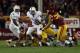 LOS ANGELES, CA - NOVEMBER 16: Quarterback Kevin Hogan #8 of the Stanford Cardinal is brought down by linebacker Hayes Pullard #10 of the USC Trojans, as defensive end J.R. Tavai #58 of the Trojans pursues the play in the fourth quarter at Los Angeles Co