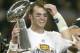 HOUSTON, TX - FEBRUARY 1: MVP Tom Brady #12 of the New England Patriots raises the Lombardi trophy as he is interviewed by television commentator Jim Nance after defeating the Carolina Panthers 32-29 in Super Bowl XXXVIII at Reliant Stadium on February 1