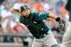 BALTIMORE, MD - AUGUST 24: Kurt Suzuki #22 of the Oakland Athletics fields a bunt and throws to first base in the eighth inning against the Baltimore Orioles at Oriole Park at Camden Yards on August 24, 2013 in Baltimore, Maryland. (Photo by Greg Fiume/