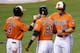 BALTIMORE, MD - AUGUST 17: Steve Pearce #28 of the Baltimore Orioles celebrates scoring a run with teammates Nate McLouth #9 and Nick Markakis #21 during the third inning against the Colorado Rockies at Oriole Park at Camden Yards on August 17, 2013 in Ba
