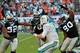 Nov 24, 2013; Miami Gardens, FL, USA; Carolina Panthers defensive tackle Dwan Edwards (left), guard Nate Chandler (center), and defensive end Frank Alexander (right) tackle Miami Dolphins quarterback Ryan Tannehill (17) during the second half at Sun Life