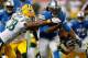 DETROIT, MI - NOVEMBER 28: Joique Bell #35 of the Detroit Lions tries to split the tackles of M.D. Jennings #43 and Tramon Williams #38 of the Green Bay Packers during a third quarter run at Ford Field on November 28, 2013 in Detroit, Michigan. (Photo by