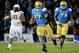 PASADENA, CA - NOVEMBER 23: Brett Hundley #17 of the UCLA Bruins carries the ball for a first down in front of Will Sutton #90 of the Arizona State Sun Devils and teammate Caleb Benenoch #74 during the fourth quarter at Rose Bowl on November 23, 2013 in