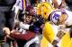 BATON ROUGE, LA - NOVEMBER 23: Quarterback Johnny Manziel #2 of the Texas A&M Aggies is tackled by linebacker Lamin Barrow #18 and cornerback Jalen Mills #28 of the LSU Tigers at Tiger Stadium on November 23, 2013 in Baton Rouge, Louisiana. (Photo by Se