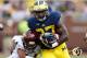 ANN ARBOR, MI - AUGUST 31: Derrick Green #27 of the Michigan Wolverines tries to escape the Jason Wilson #14 of the Central Michigan Chippewas during a third quarter run at Michigan Stadium on August 31, 2013 in Ann Arbor, Michigan. (Photo by Gregory Sha