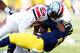 ANN ARBOR, MI - NOVEMBER 30: Wide receiver Jeremy Gallon #21 of the Michigan Wolverines is tackled by defensive back Tyvis Powell #23 of the Ohio State Buckeyes in the first quarter during a game at Michigan Stadium on November 30, 2013 in Ann Arbor, Mich