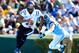 CHAPEL HILL, NC - NOVEMBER 30: Anthony Boone #7 of the Duke Blue Devils rolls ut under pressure from Jeff Schoettmer #34 of the North Carolina Tar Heels during play at Kenan Stadium on November 30, 2013 in Chapel Hill, North Carolina. (Photo by Grant Ha
