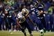SEATTLE, WA - DECEMBER 02: Quarterback Russell Wilson #3 of the Seattle Seahawks runs with the ball as outside linebacker David Hawthorne #57 of the New Orleans Saints defends during a game at CenturyLink Field on December 2, 2013 in Seattle, Washington.