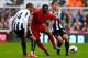 NEWCASTLE-UPON-TYNE, ENGLAND - OCTOBER 19: Loic Remy (L) and Hatem Ben Arfa of Newcastle in action with Kolo Toure (C) of Liverpool during the Barclays Premier League match between Newcastle United and Liverpool at St James' Park on October 19, 2013 in Ne