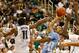 EAST LANSING, MI - DECEMBER 04: Nate Britt #0 of the North Carolina Tar Heels tries to get a first half shot off over Keith Appling #11 of the Michigan State Spartans at the Jack T. Breslin Student Events Center on December 4, 2013 in East Lansing, Michig