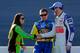 Danica Patrick and Dale Earnhardt Jr. shake hands while Ricky Stenhouse Jr. looks on.