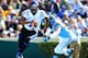 CHAPEL HILL, NC - NOVEMBER 30: Anthony Boone #7 of the Duke Blue Devils rolls ut under pressure from Jeff Schoettmer #34 of the North Carolina Tar Heels during play at Kenan Stadium on November 30, 2013 in Chapel Hill, North Carolina. (Photo by Grant Ha