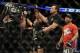 Jan 26, 2013; Chicago, IL, USA; Demetrious Johnson (middle) celebrates after defeating John Dodson (right) during UFC on FOX 6 for the world flyweight championship at the United Center. Mandatory Credit: David Banks-USA TODAY Sports