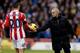 STOKE ON TRENT, ENGLAND - DECEMBER 07: Chelsea manager Jose Mourhino hands the ball to Stoke's Geoff Cameron during the Barclays Premier League match between Stoke City and Chelsea at Britannia Stadium on December 7, 2013 in Stoke on Trent, England. (Ph
