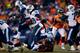 DENVER, CO - DECEMBER 8: Running back Chris Johnson #28 of the Tennessee Titans jumps over a defender while carrying the ball during the third quarter against the Denver Broncos at Sports Authority Field Field at Mile High on December 8, 2013 in Denver,