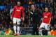 MANCHESTER, ENGLAND - DECEMBER 10: Robin van Persie (L) and Tom Cleverley of Manchester United prepare to come on as substitutes as Manager David Moyes looks on during the UEFA Champions League Group A match between Manchester United and Shakhtar Donets