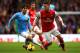 MANCHESTER, ENGLAND - DECEMBER 14: David Silva of Manchester City marshalls Mesut Oezil of Arsenal during the Barclays Premier League match between Manchester City and Arsenal at Etihad Stadium on December 14, 2013 in Manchester, England. (Photo by Richar