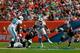 MIAMI GARDENS, FL - DECEMBER 15: Daniel Thomas #33 of the Miami Dolphins rushes the ball under pressure from Jamie Collins #91 of the New England Patriots at Sun Life Stadium on December 15, 2013 in Miami Gardens, Florida. (Photo by Chris Trotman/Getty