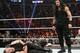 Dean Ambrose writhes after taking a spear from Roman Reigns.