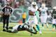 EAST RUTHERFORD, NJ - DECEMBER 01: Charles Clay #42 of the Miami Dolphins runs after a catch as DeMario Davis #56 of the New York Jets misses the tackle during their game at MetLife Stadium on December 1, 2013 in East Rutherford, New Jersey. (Photo by