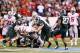 INDIANAPOLIS, IN - DECEMBER 07: Carlos Hyde #34 of the Ohio State Buckeyes is tackled by the defense of the Michigan State Spartans during the Big Ten Conference Championship game at Lucas Oil Stadium on December 7, 2013 in Indianapolis, Indiana. (Photo