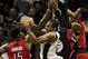Dec 23, 2013; San Antonio, TX, USA; San Antonio Spurs forward Kawhi Leonard (center) pulls down a rebound against Toronto Raptors forward Amir Johnson (left) and guard Terrence Ross (right) during the first half at AT&T Center. Mandatory Credit: Soobum I
