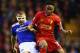 LIVERPOOL, ENGLAND - JANUARY 05: James Wesolowski of Oldham challenges Raheem Sterling of Liverpool during the Budweiser FA Cup third round match between Liverpool and Oldham Athletic at Anfield on January 5, 2014 in Liverpool, England. (Photo by Clive