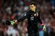 LONDON, ENGLAND - OCTOBER 15: Wojciech Szczesny of Poland throws the discarded headgear of Wayne Rooney during the FIFA 2014 World Cup Qualifying Group H match between England and Poland at Wembley Stadium on October 15, 2013 in London, England. (Photo