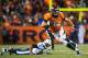DENVER, CO - DECEMBER 8: Tight end Jacob Tamme #84 of the Denver Broncos gains yards after the catch as free safety George Wilson #21 of the Tennessee Titans lies on the ground after missing a tackle at Sports Authority Field Field at Mile High on Decemb