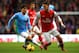 MANCHESTER, ENGLAND - DECEMBER 14: David Silva of Manchester City marshalls Mesut Oezil of Arsenal during the Barclays Premier League match between Manchester City and Arsenal at Etihad Stadium on December 14, 2013 in Manchester, England. (Photo by Richar