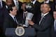 WASHINGTON, DC - JANUARY 14: National Basketball Association 2012-2013 champion Miami Heat Head Coach Erik Spoelstra (L) presents a commemorative trophy to President Barack Obama during an event at the White House January 14, 2014 in Washington, DC. This