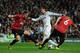 MADRID, SPAIN - FEBRUARY 13: Cristiano Ronaldo of Real Madrid is put under pressure by Jonny Evans and Phil Jones of Manchester United during the UEFA Champions League Round of 16 first leg match between Real Madrid and Manchester United at Estadio Sant