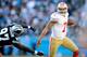 CHARLOTTE, NC - JANUARY 12: Colin Kaepernick #7 of the San Francisco 49ers avoids being tackled by Mario Addison #97 of the Carolina Panthers in the fourth quarter during the NFC Divisional Playoff Game at Bank of America Stadium on January 12, 2014 in Ch