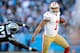 CHARLOTTE, NC - JANUARY 12: Colin Kaepernick #7 of the San Francisco 49ers avoids being tackled by Mario Addison #97 of the Carolina Panthers in the fourth quarter during the NFC Divisional Playoff Game at Bank of America Stadium on January 12, 2014 in Ch